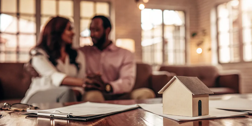 Couple reviewing mortgage documents with a loan officer in a bright modern office