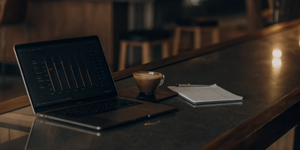 A clean modern workspace with a laptop displaying a digital mortgage shopping checklist