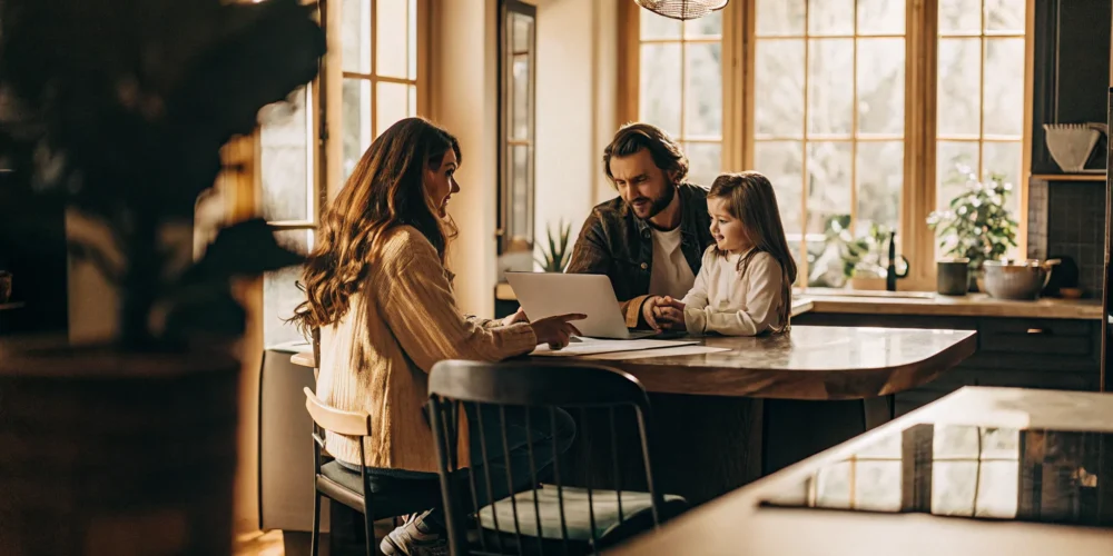 Family reviewing mortgage paperwork with a financial advisor at a kitchen table